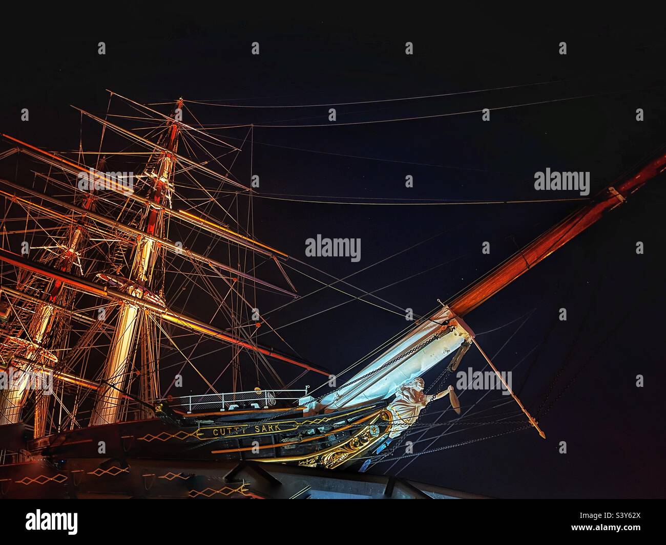 Cutty Sark, the celebrated historic sailing ship and fastest of its time. Now an award-winning visitor attraction in Greenwich, London at night with the ship’s figurehead clearly seen - Smartphone Captured Stock Image