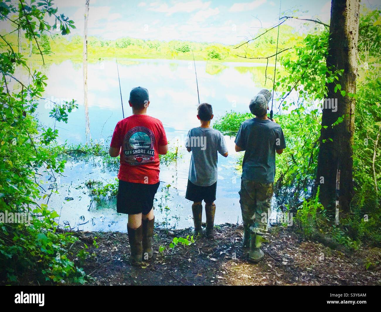 Boys fishing in secluded lake Stock Photo