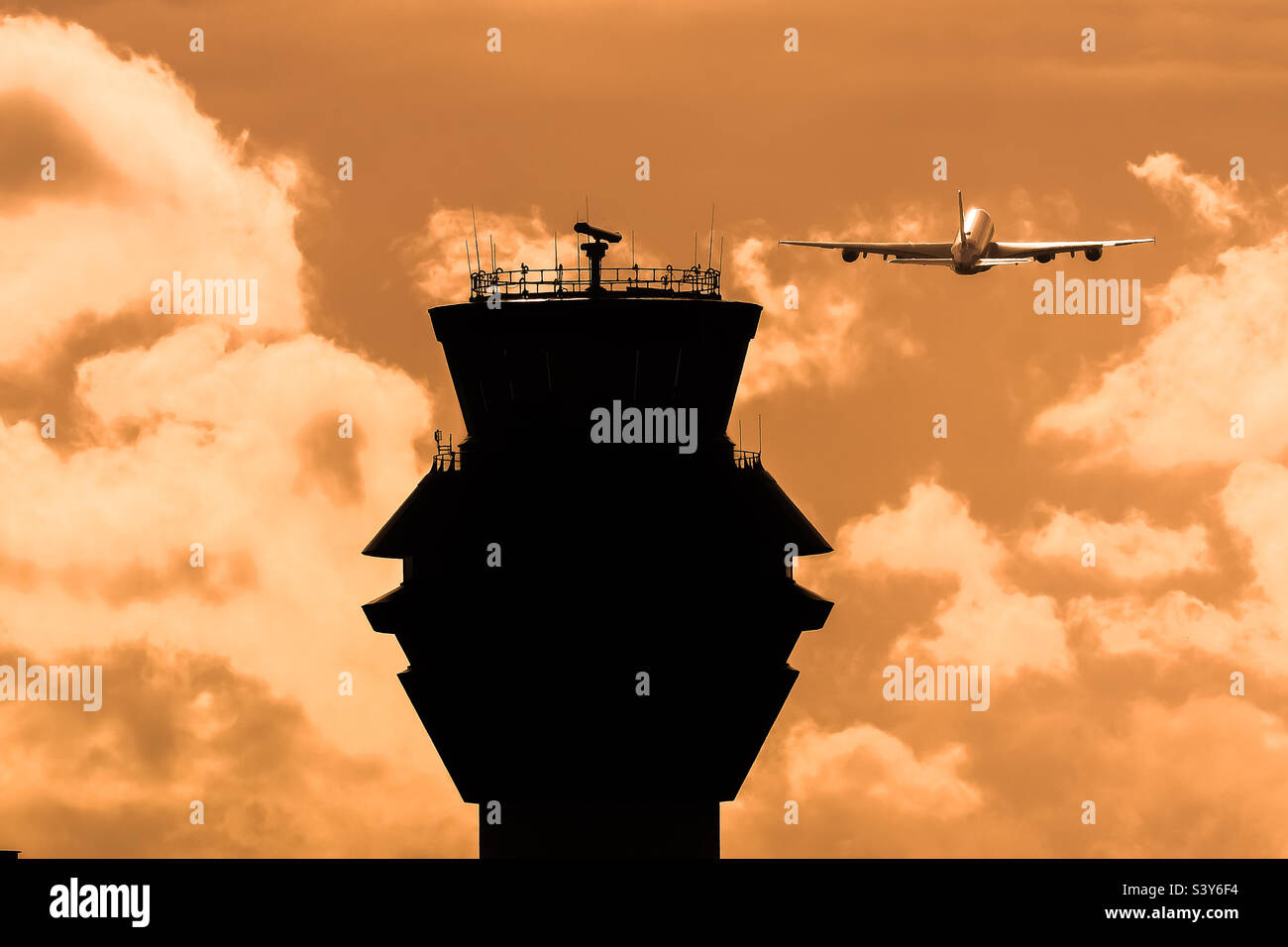 Airport ATC tower and plane airborne. Stock Photo