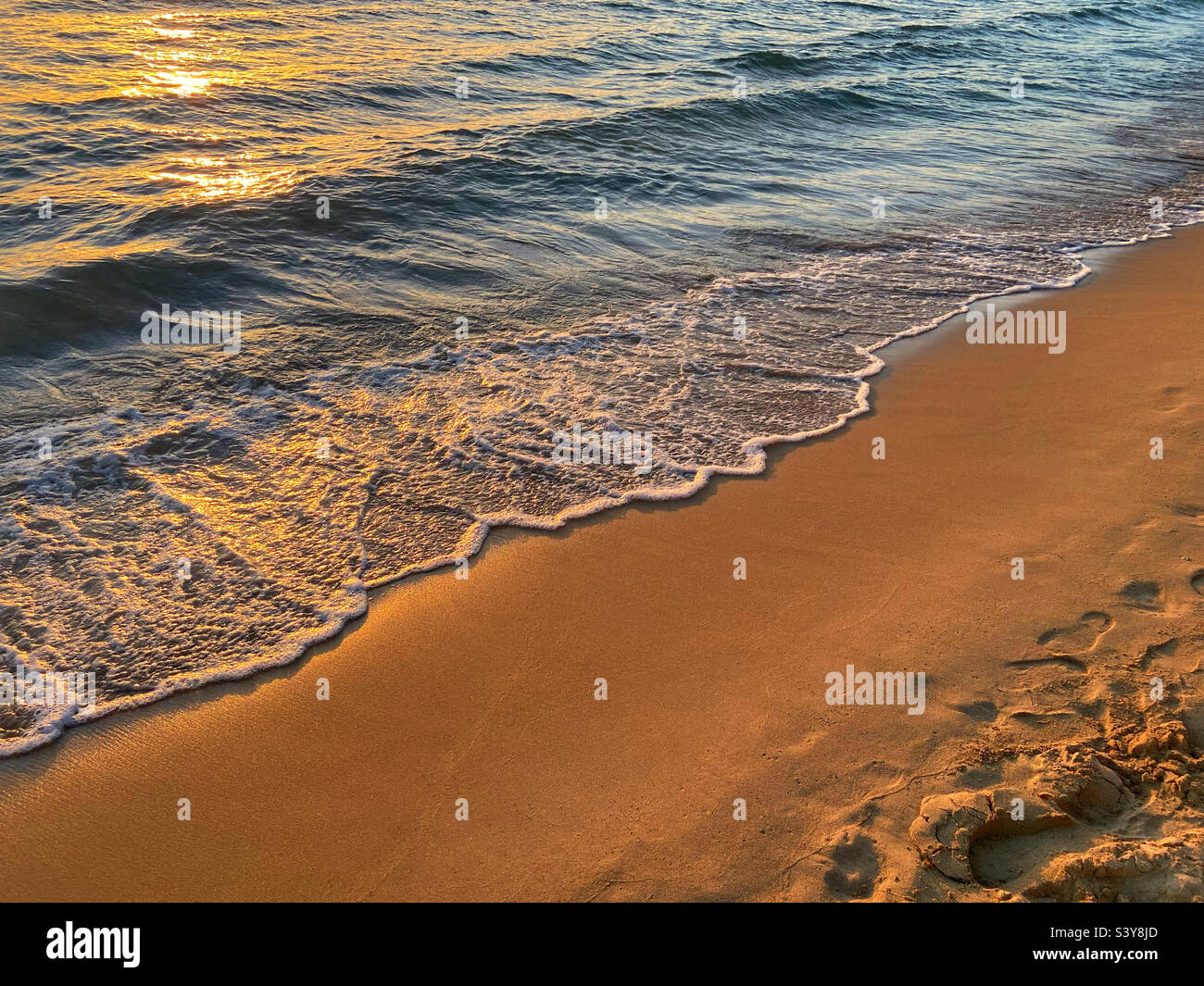 Sea breaking on beach at sunset. Lardos bay at Kefkos island of Rhodes, Greece Stock Photo