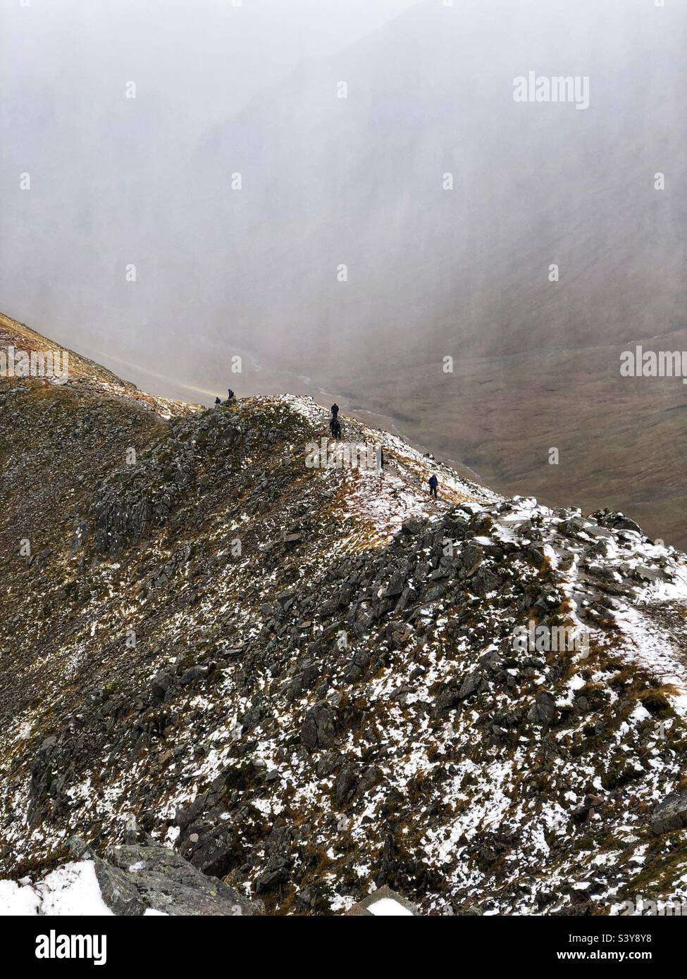 Walkers on the path and slopes of a snow covered Munro Buachaille Etive Beag, Glencoe, Scotland - Smartphone Captured Stock Image