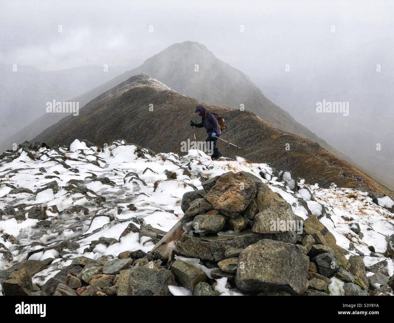 Walkers on the path and slopes of a snow covered Munro Buachaille Etive Beag, Glencoe, Scotland - Smartphone Captured Stock Image
