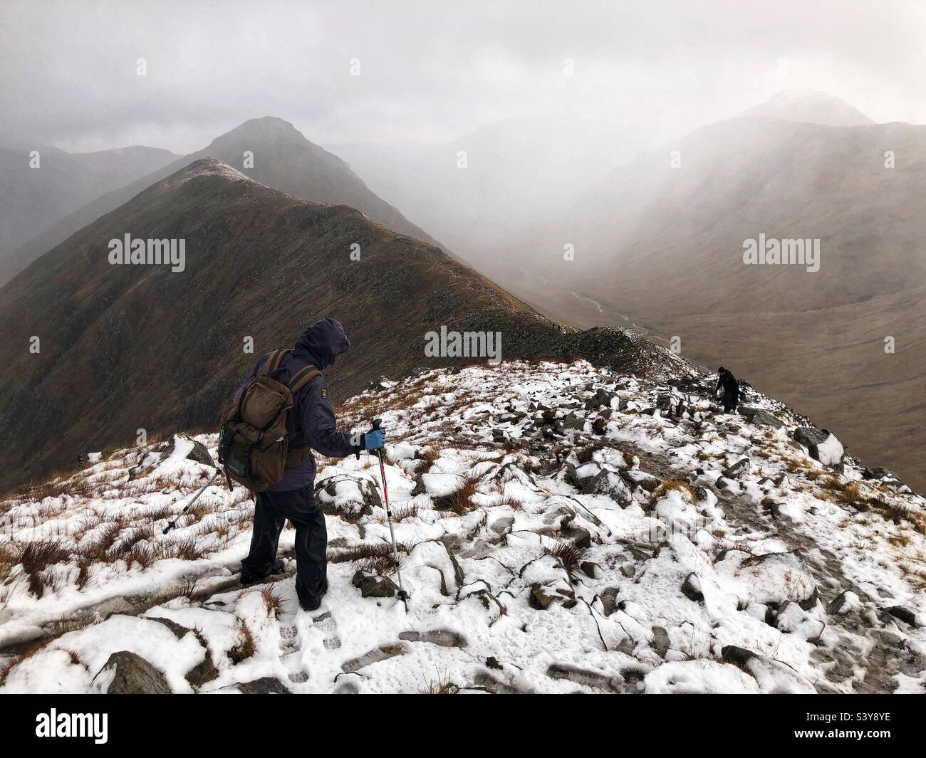 Walkers on the path and slopes of a snow covered Munro Buachaille Etive Beag, Glencoe, Scotland - Smartphone Captured Stock Image