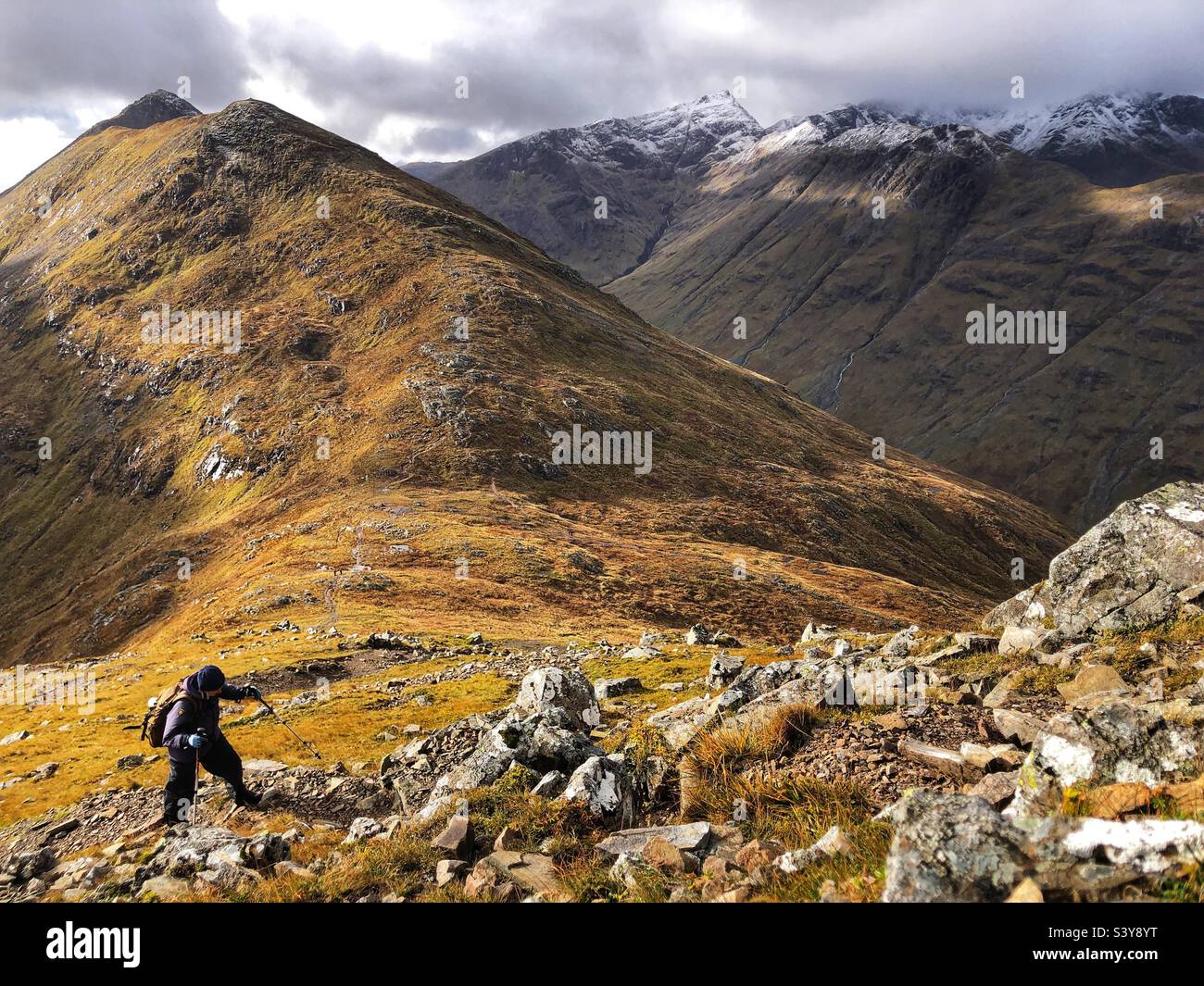 Female Walker on the path and snow covered slopes of Munro Buachaille Etive Beag, Glencoe, Scotland - Smartphone Captured Stock Image