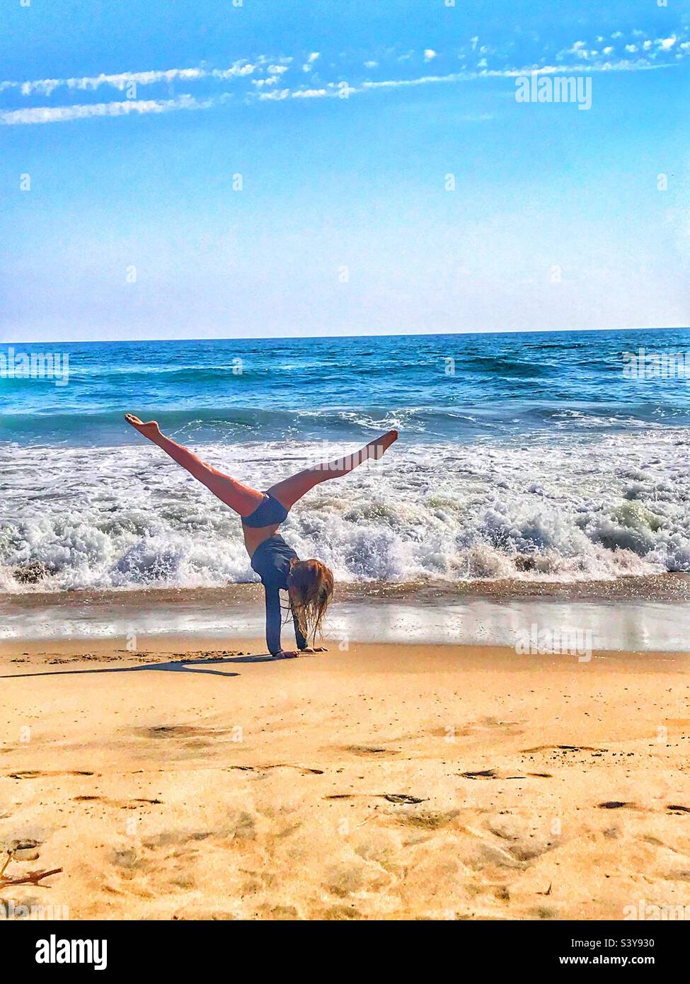 Young girl doing gymnastics on the beach Stock Photo - Alamy