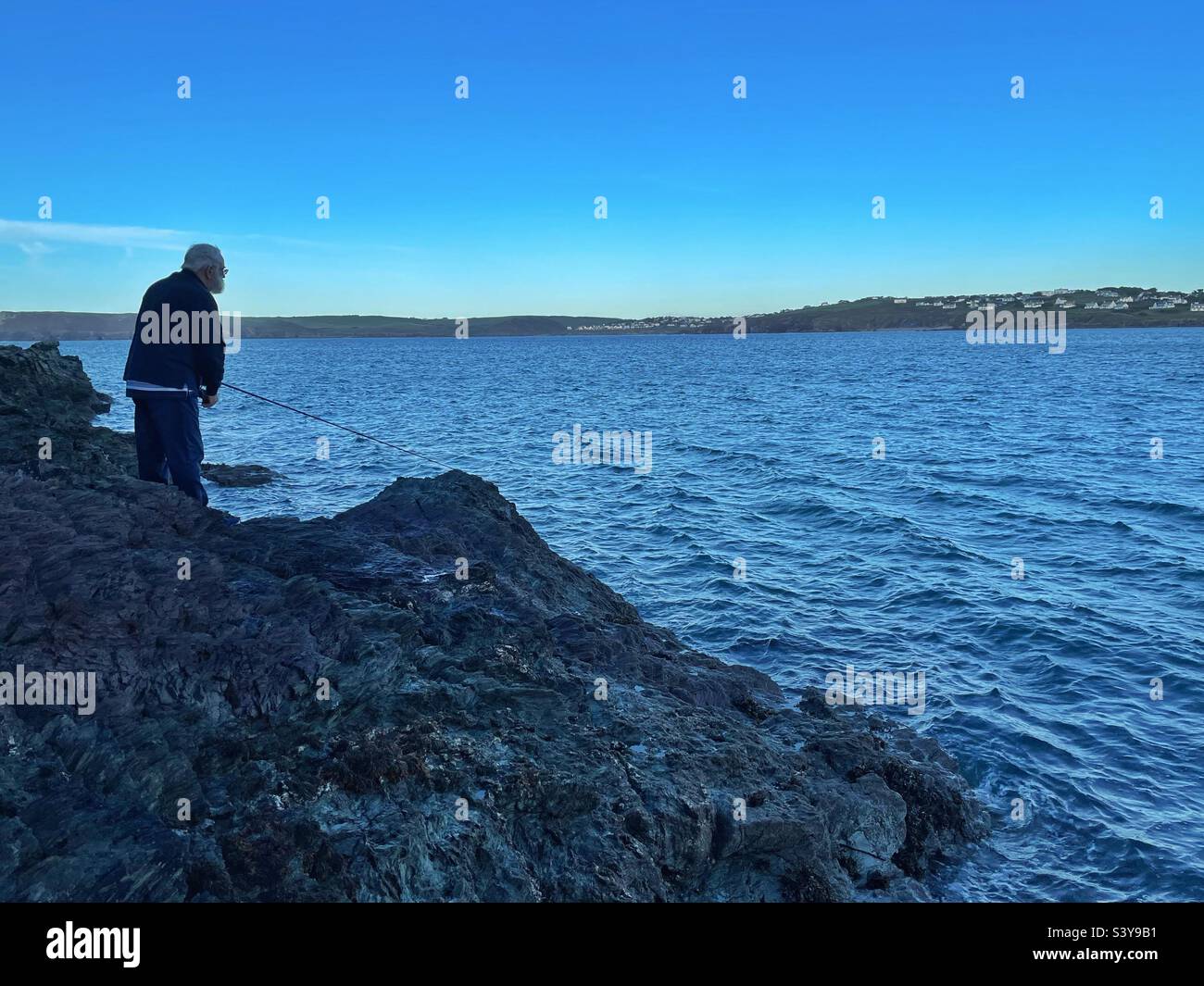 Elderly gentleman fishing on the Camel estuary, North Cornwall, dusk, October. - Smartphone Captured Stock Image