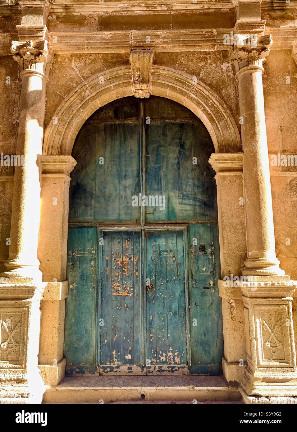 Large stone doorway with old wooden doors in Marsala, Sicily, Italy. Stock Photo