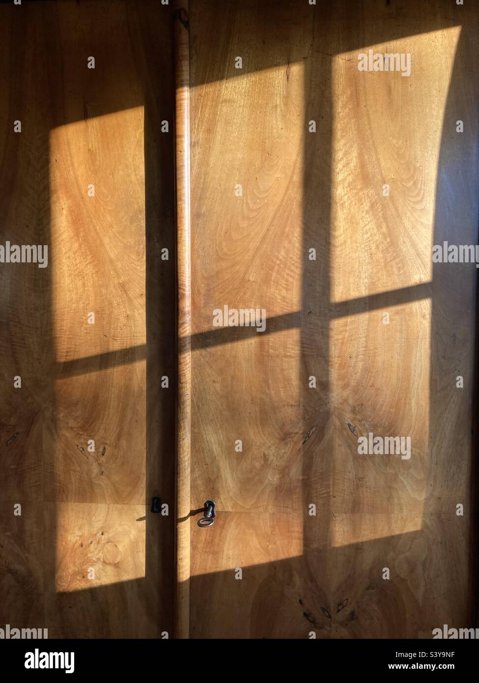 Shadow of a window on a wooden cupboard door - Smartphone Captured Stock Image