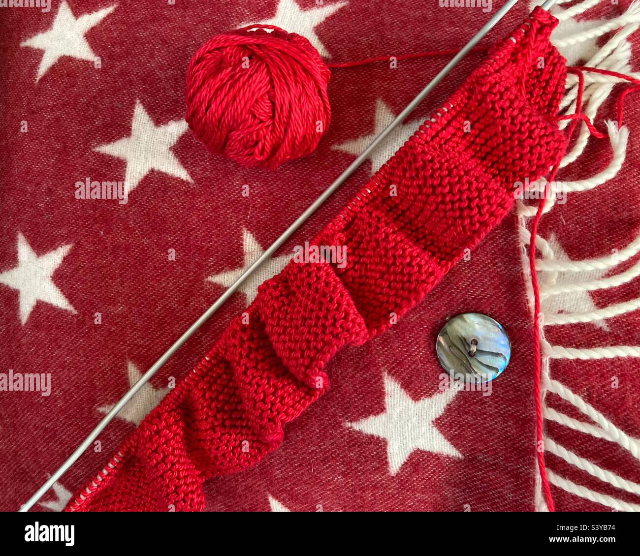 Winter knitting with red wool Stock Photo