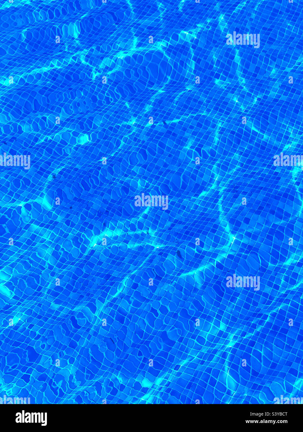 Water in a swimming pool on a hot summer’s day. Blue tiles and sparkling ripples. An image of summer holidays. Photo ©️ COLIN HOSKINS. - Smartphone Captured Stock Image