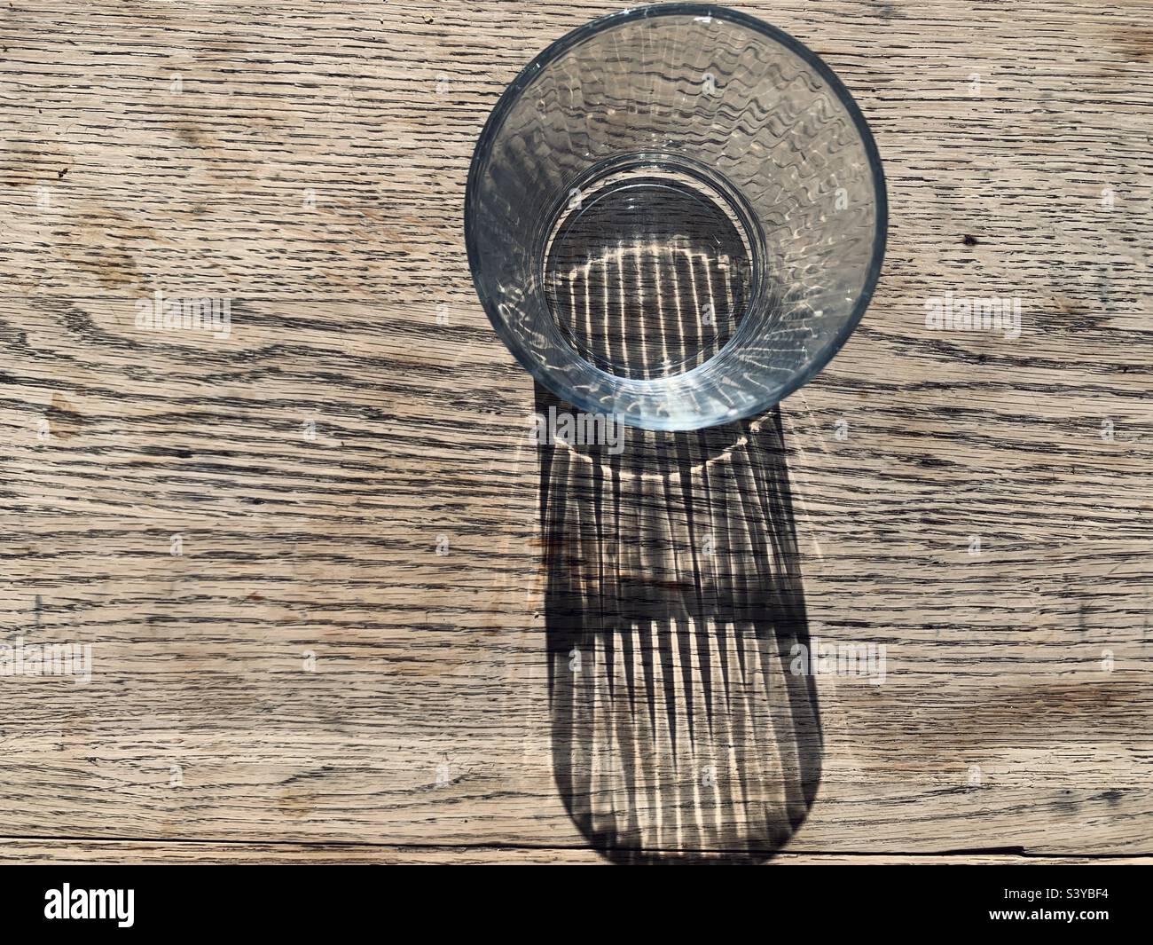 Glass on table with cast shadows - Smartphone Captured Stock Image