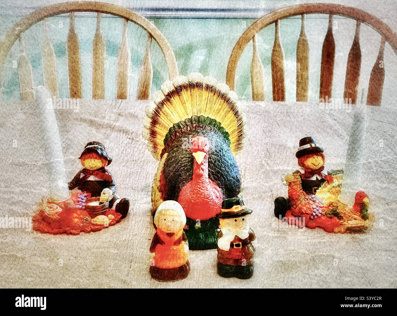 Turkey decor centerpiece and seasonal pilgrim salt and pepper shakers and candleholders on a tabletop in Utah, USA near the Thanksgiving holiday season. Grunge digitally added for vintage feel. - Smartphone Captured Stock Image