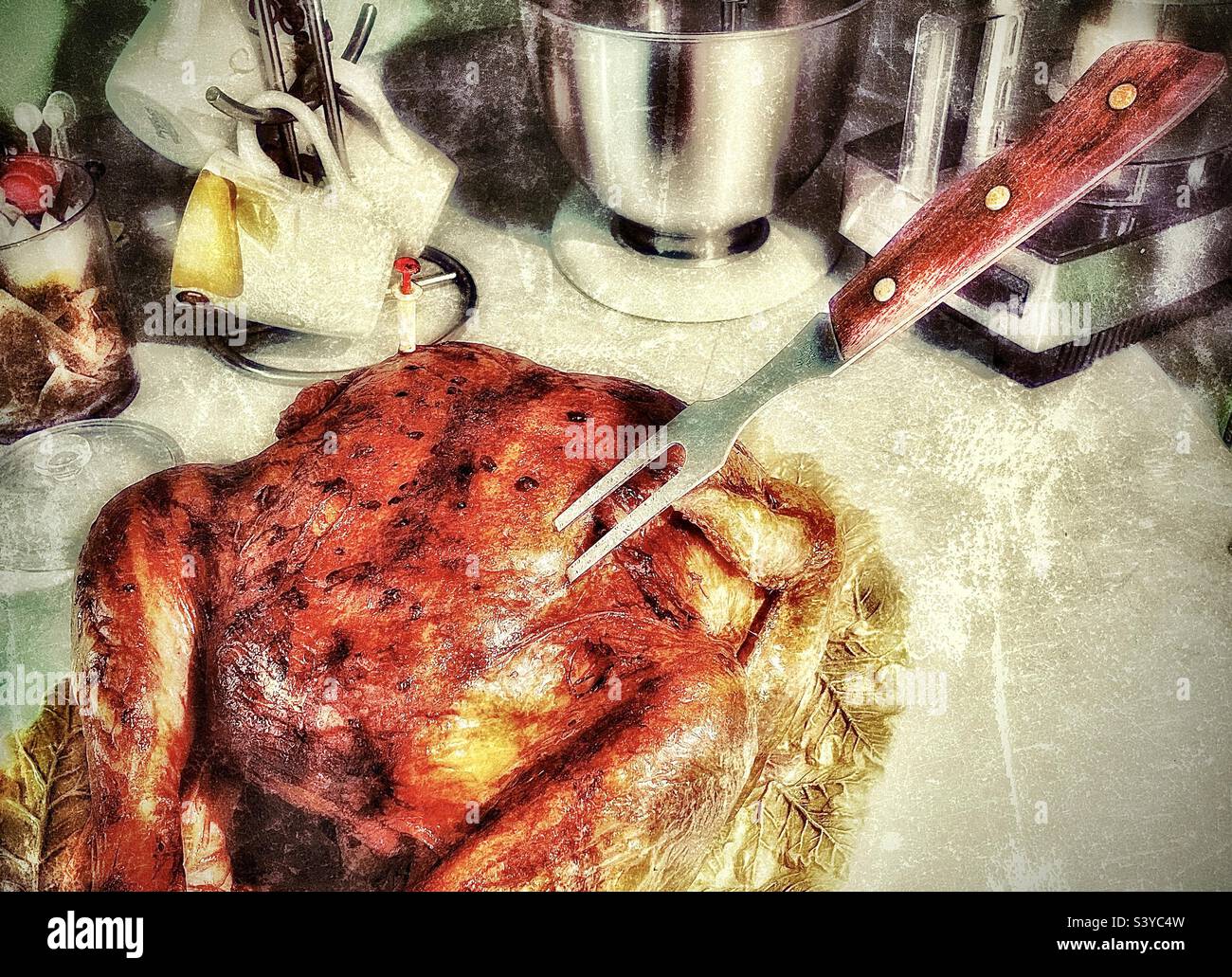 A golden brown turkey, fresh out of the oven, rests on a kitchen countertop in Utah, USA, with a meat fork stuck in it as dinner time draws near. Grunge effect digitally added. - Smartphone Captured Stock Image