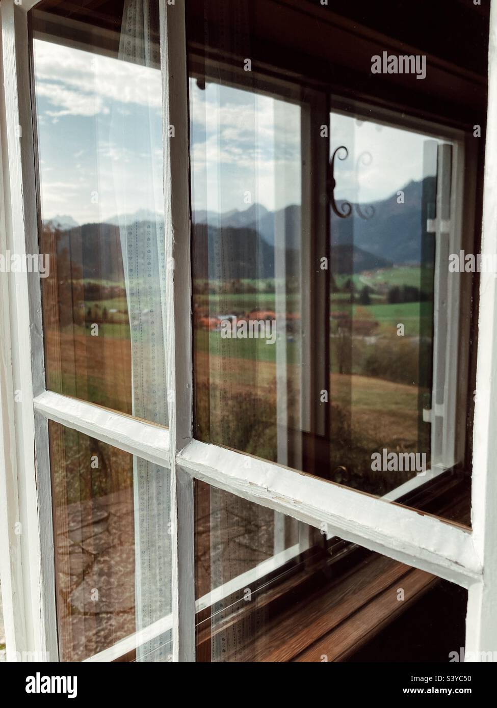 Landscape of the German alps mirrored in the window - Smartphone Captured Stock Image