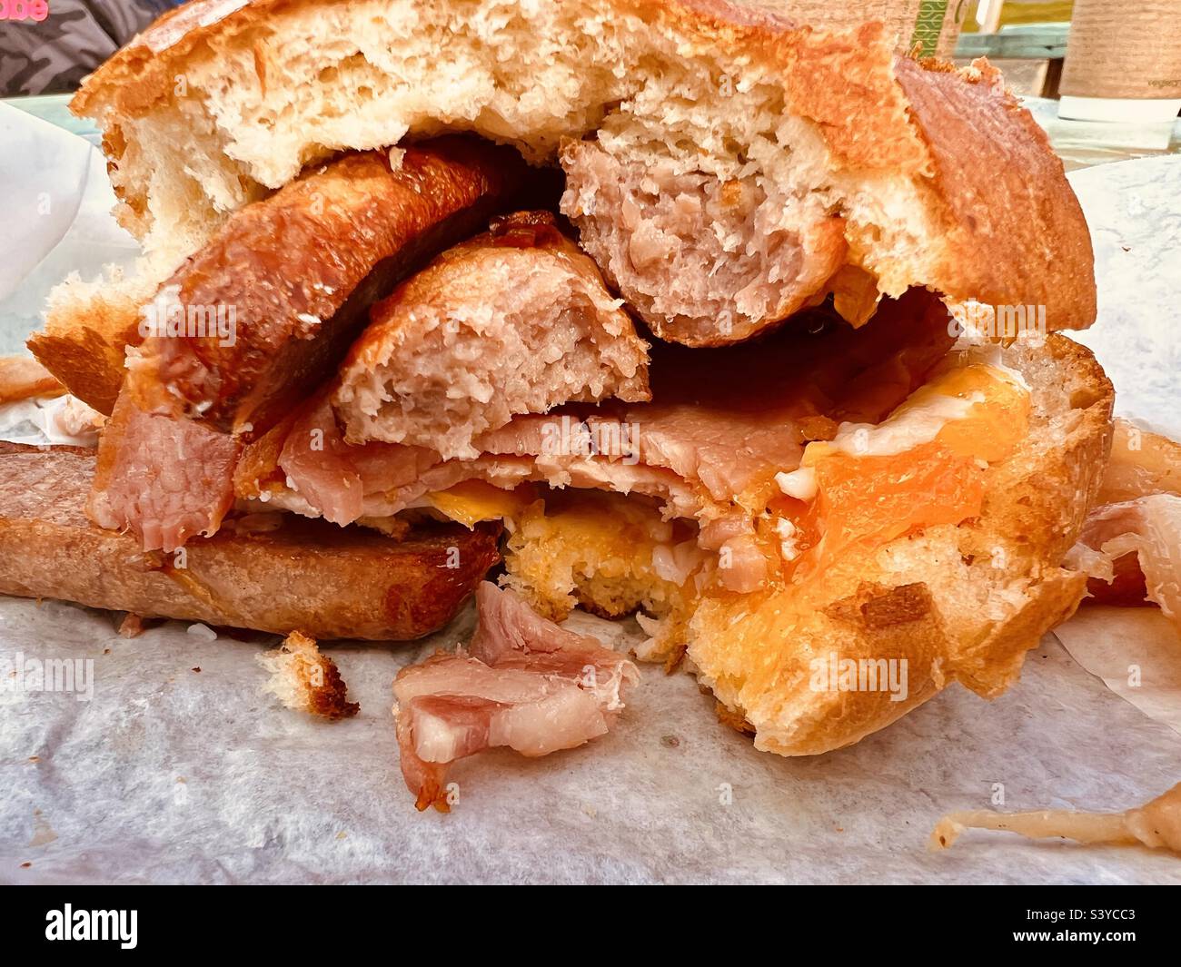 Bacon sausage and egg roll half eaten Stock Photo Alamy