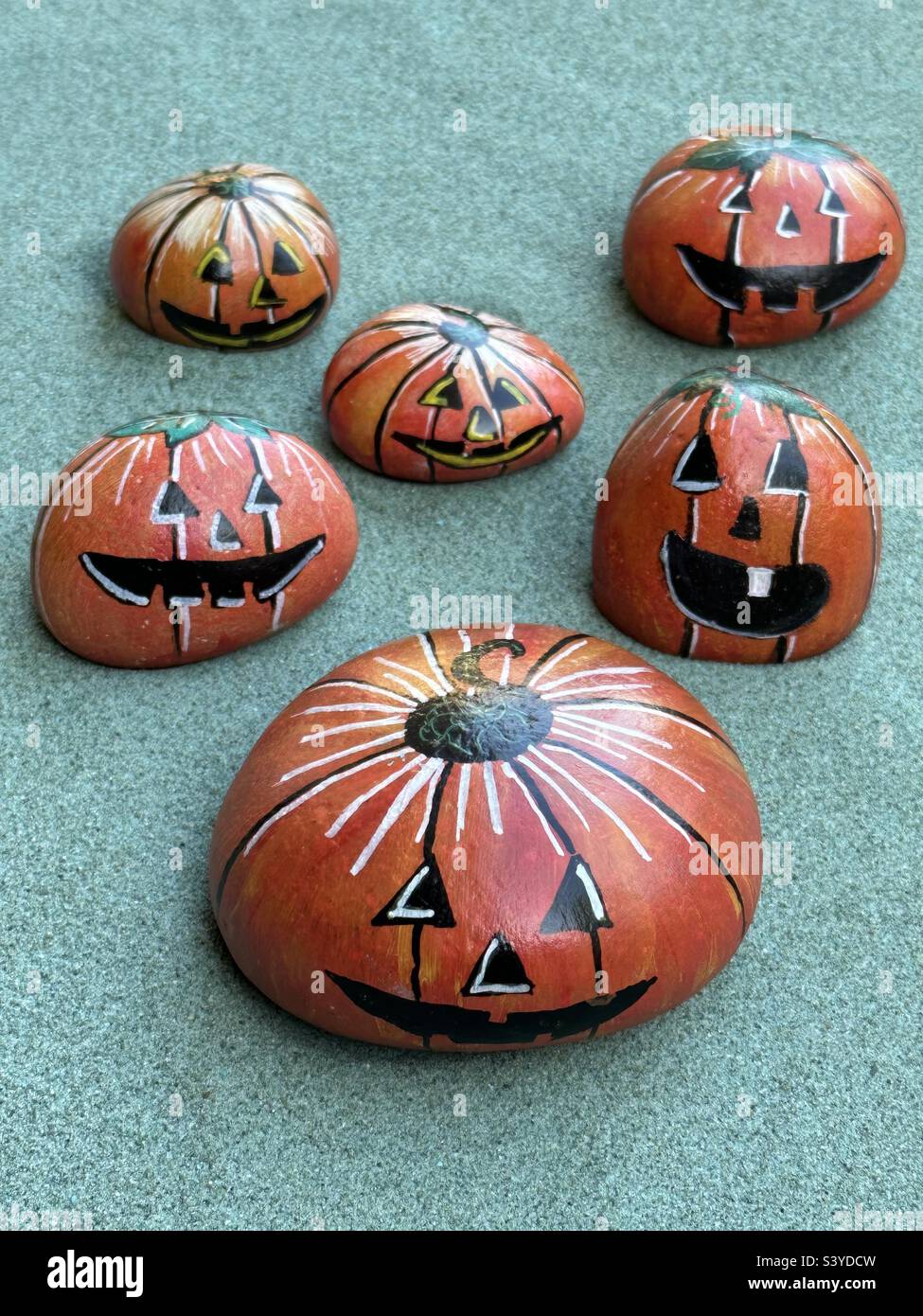 Halloween stone pumpkins over green sand - Smartphone Captured Stock Image
