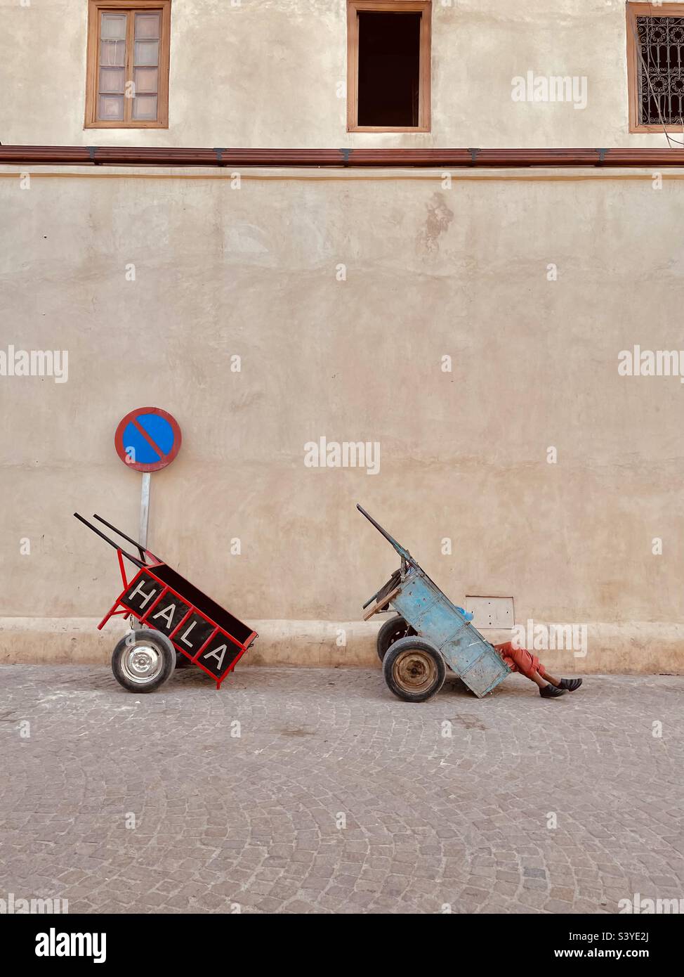 Pushcarts waiting for customers with owner resting in the push cart - Smartphone Captured Stock Image