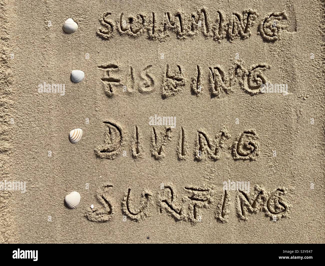 In the sand are listed vacation activities - Smartphone Captured Stock Image