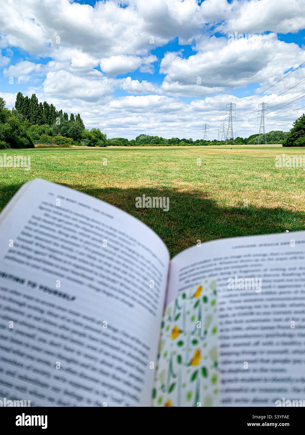 View of an open book against a landscape - Smartphone Captured Stock Image