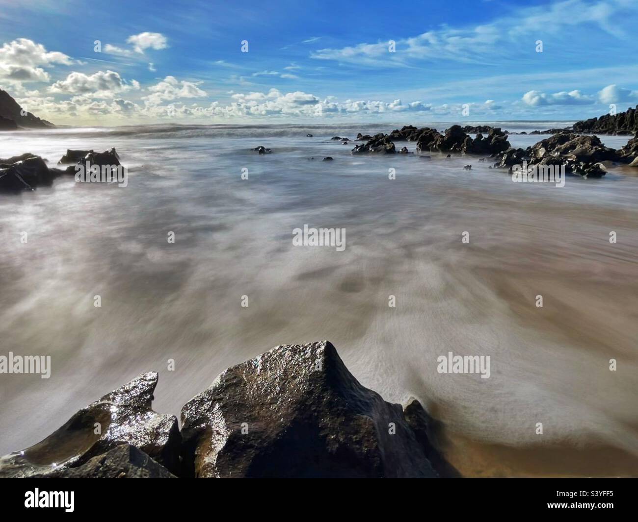 Waves rushing over rocks and sand at Mewslade, Gower, Wales, November. - Smartphone Captured Stock Image