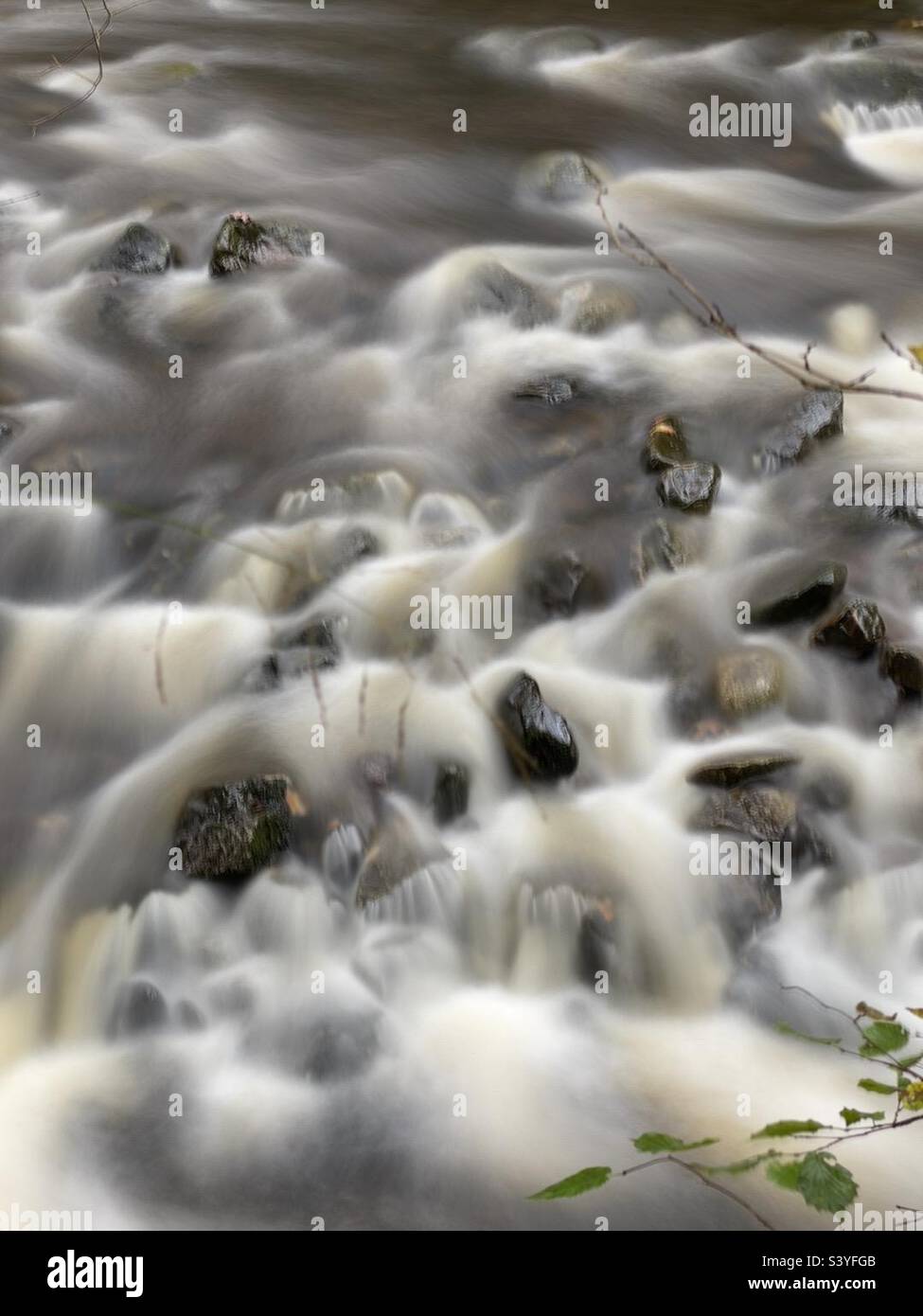 A river flowing over rocks. - Smartphone Captured Stock Image