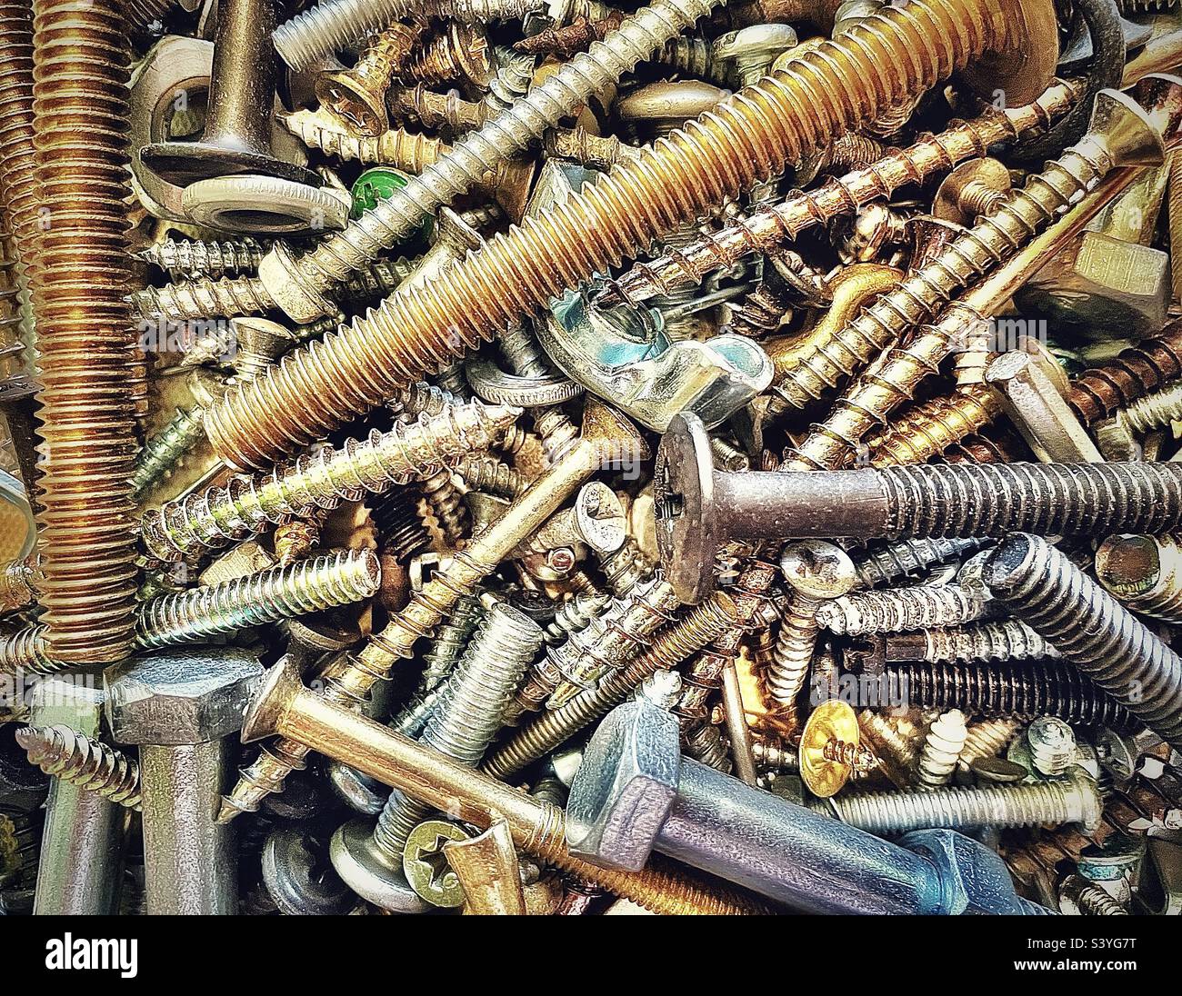 Our toolbox has a small plastic box filled with miscellaneous hardware, the assortment includes various types of screws, nuts, bolts, etc. This close view makes an interesting background and abstract. - Smartphone Captured Stock Image