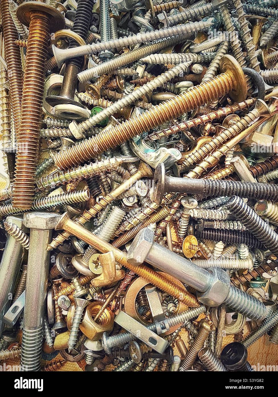 Our toolbox has a small plastic box filled with miscellaneous hardware, the assortment includes various types of screws, nuts, bolts, etc. This close view makes an interesting background and abstract. - Smartphone Captured Stock Image