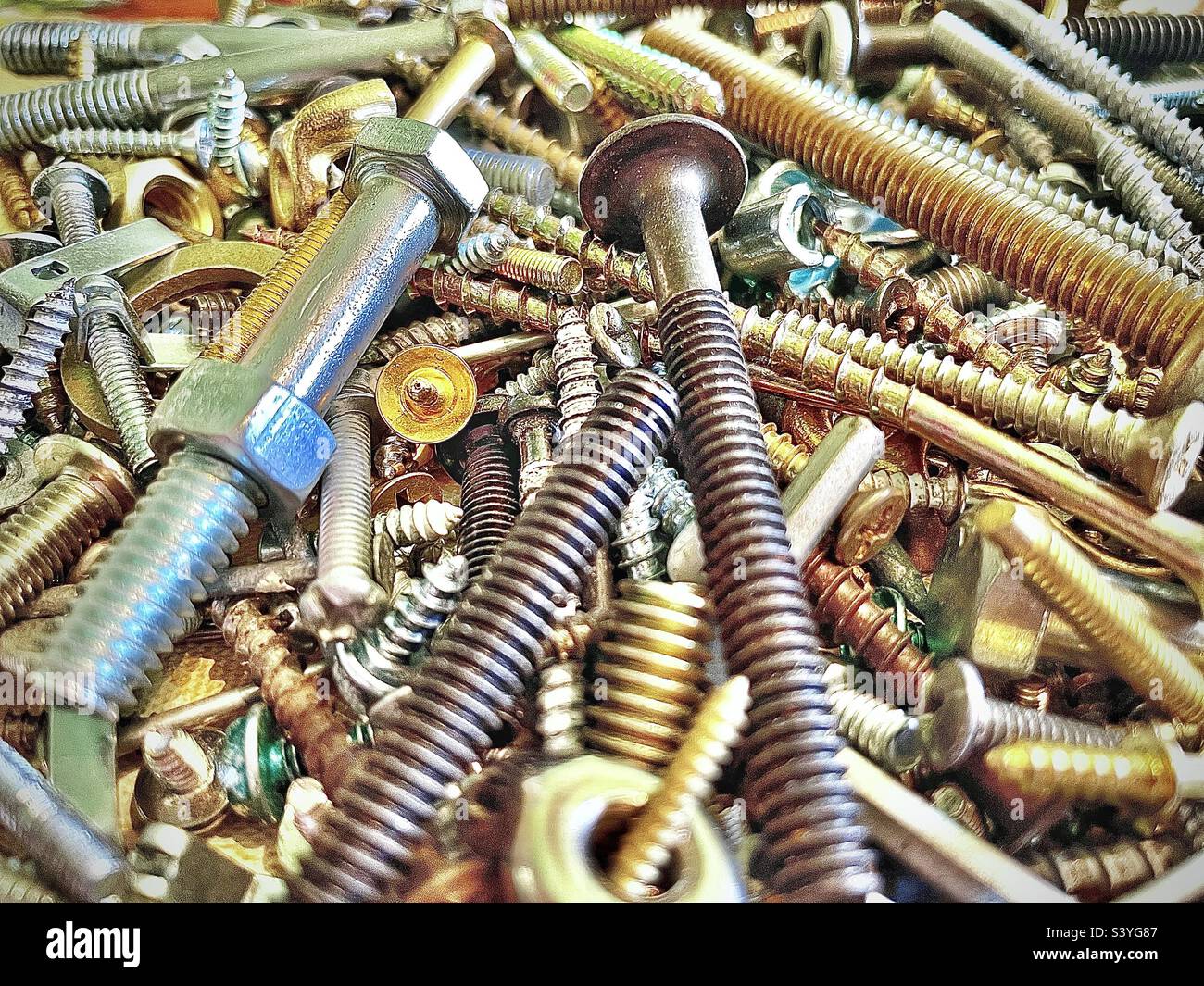 Our toolbox has a small plastic box filled with miscellaneous hardware, the assortment includes various types of screws, nuts, bolts, etc. This close view makes an interesting background and abstract. - Smartphone Captured Stock Image
