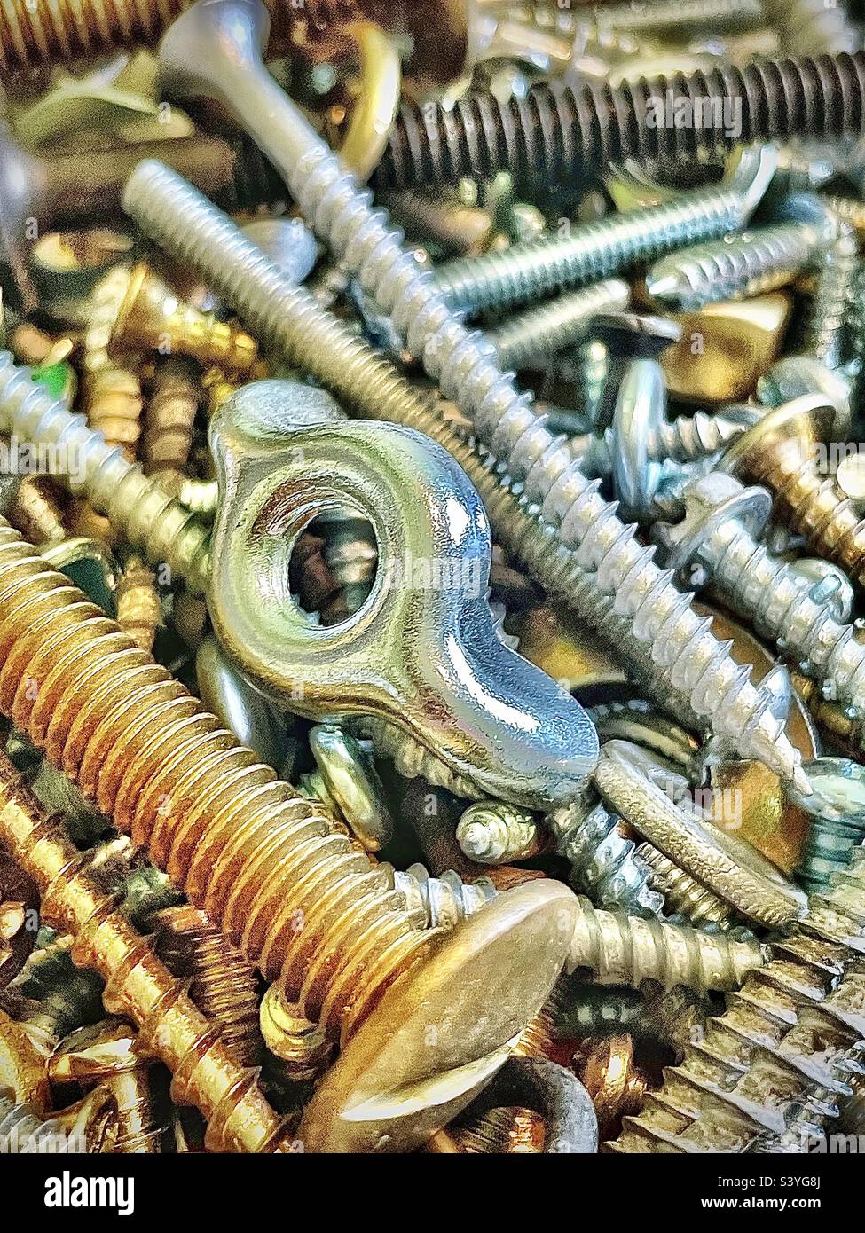 Our toolbox has a small plastic box filled with miscellaneous hardware, the assortment includes various types of screws, nuts, bolts, etc. This close view makes an interesting background and abstract. - Smartphone Captured Stock Image