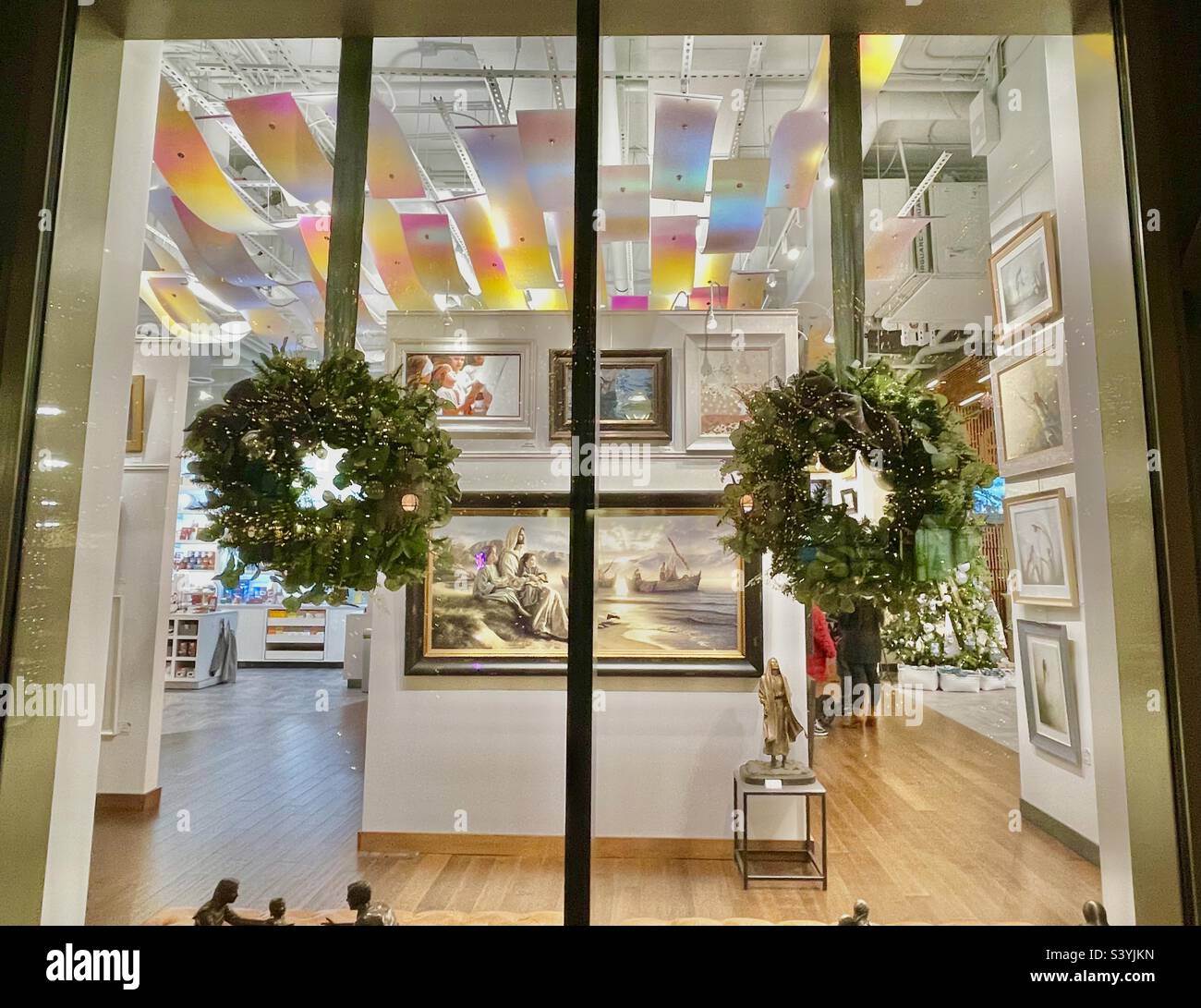 In downtown Salt  Lake City, Utah, USA during the Christmas season. Here, a look inside the decorated interior of Deseret Bookstore, a local long-standing business, after dark from the outside. - Smartphone Captured Stock Image