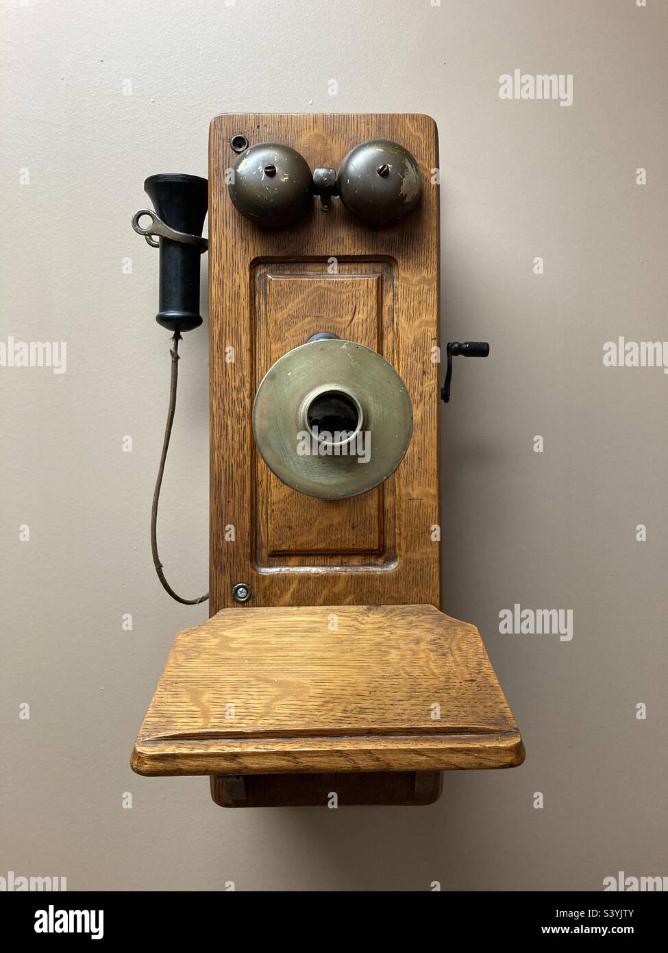 Antique, wooden telephone that hangs on the wall and looks like it has a face - Smartphone Captured Stock Image