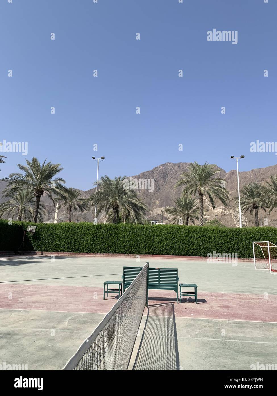 Dusty tennis court with a view of the Hajar mountains in Fujairah, UAE - Smartphone Captured Stock Image