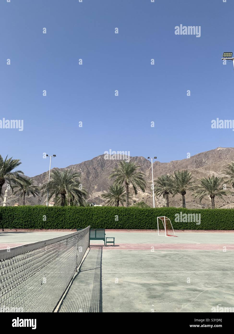 Dusty tennis court with a view of the Hajar mountains in Fujairah, UAE - Smartphone Captured Stock Image