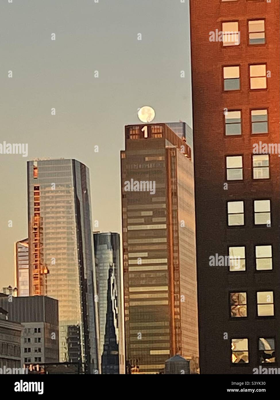 The moon Perched perfectly a top one Penn station in the early morning November 9, 2022 in New York City, USA - Smartphone Captured Stock Image