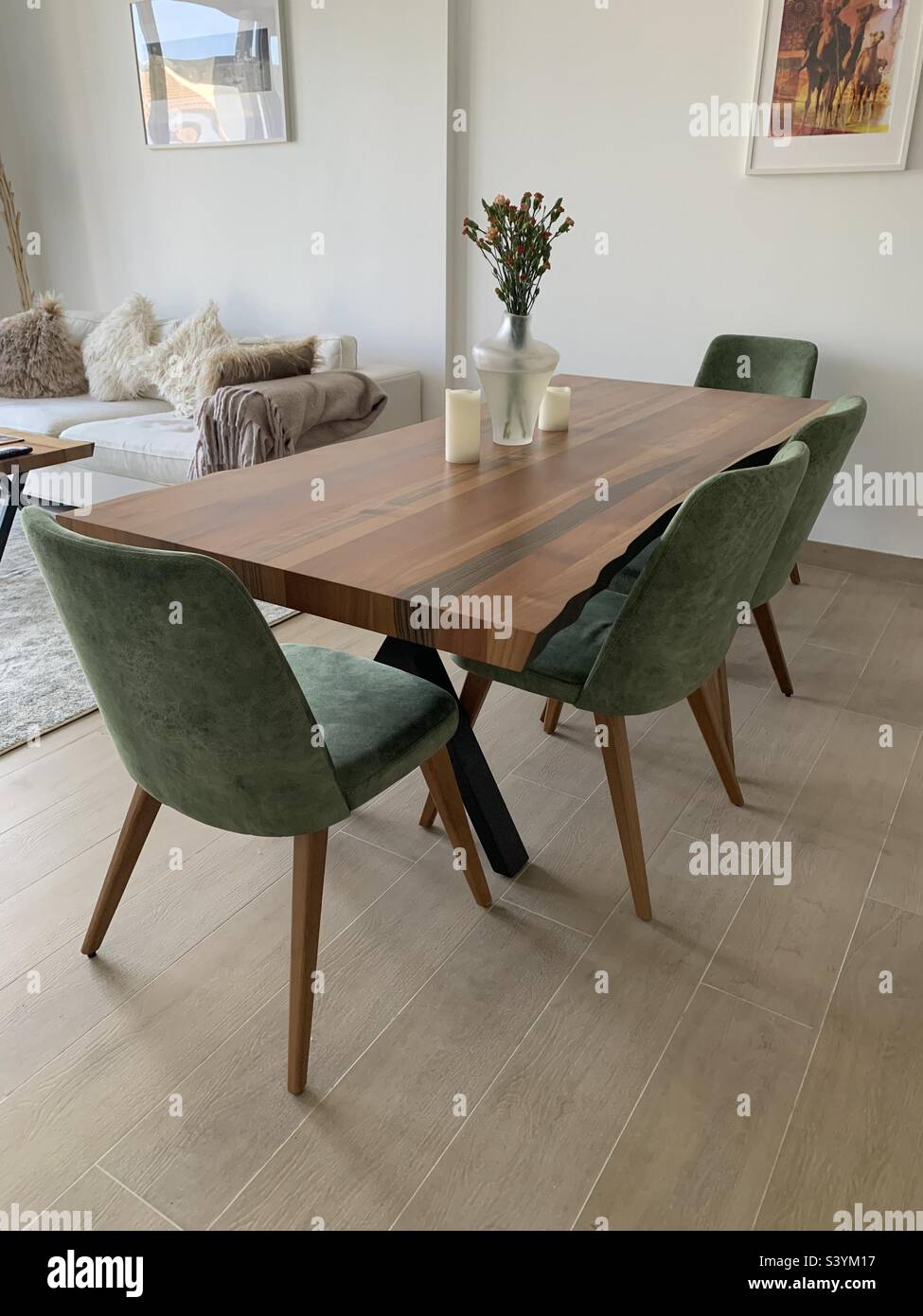 Stylish wooden dining table with green chairs in an open plan living room - Smartphone Captured Stock Image