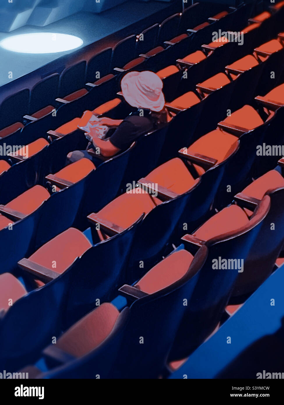 A loan woman sitting in a bank of seats in the theater venue Circle in the Square waiting the musical K-pop to begin, 2022, New York City, USA - Smartphone Captured Stock Image