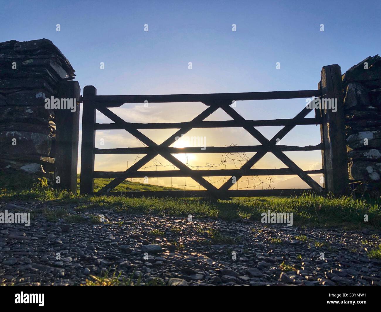 Rural Wooden farm gate backlit with low autumnal sun, Lake District England - Smartphone Captured Stock Image