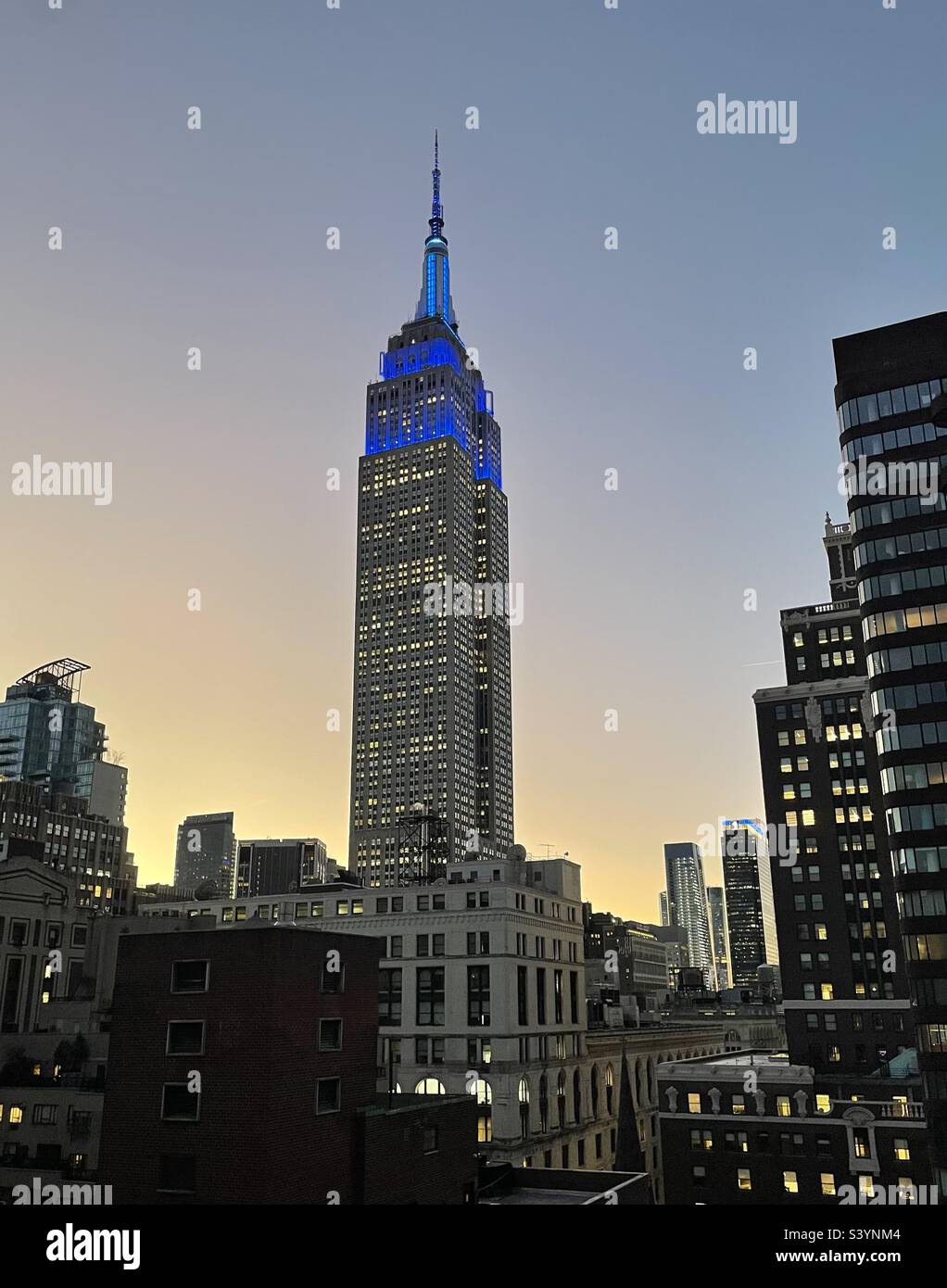 Blue tower lights on the Empire State building at dusk in New York City, USA - Smartphone Captured Stock Image