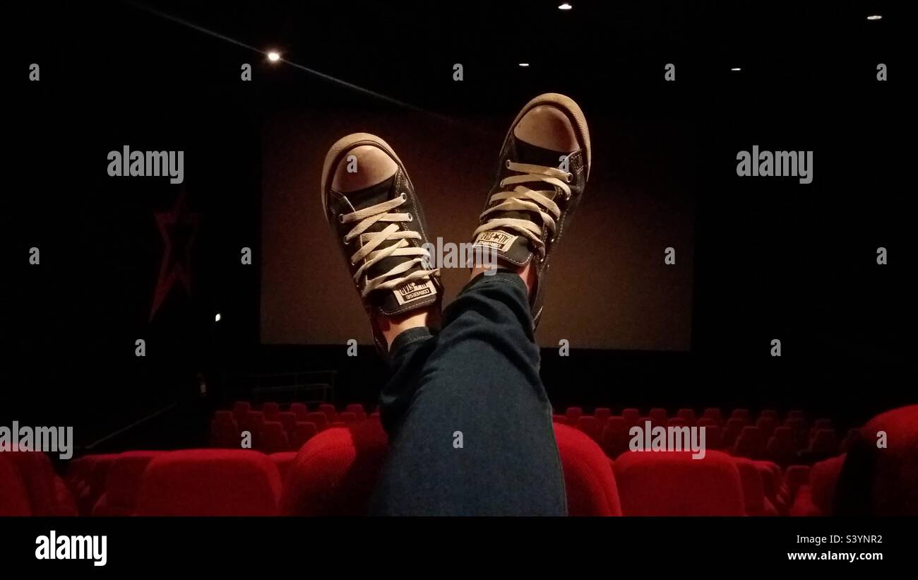 Feet up relaxing at a cinema watching a film Stock Photo