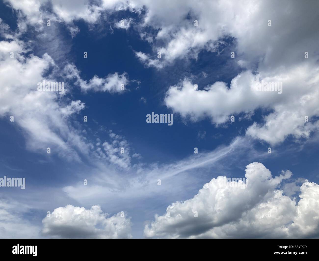 Wispy clouds with a sky blue background. If you look, you can see the shape of a heart in the middle. - Smartphone Captured Stock Image