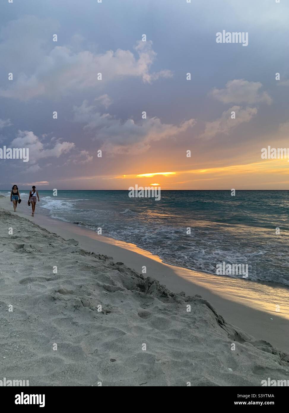 Two women walking along varadero beach. Varadero, Cuba - Smartphone Captured Stock Image