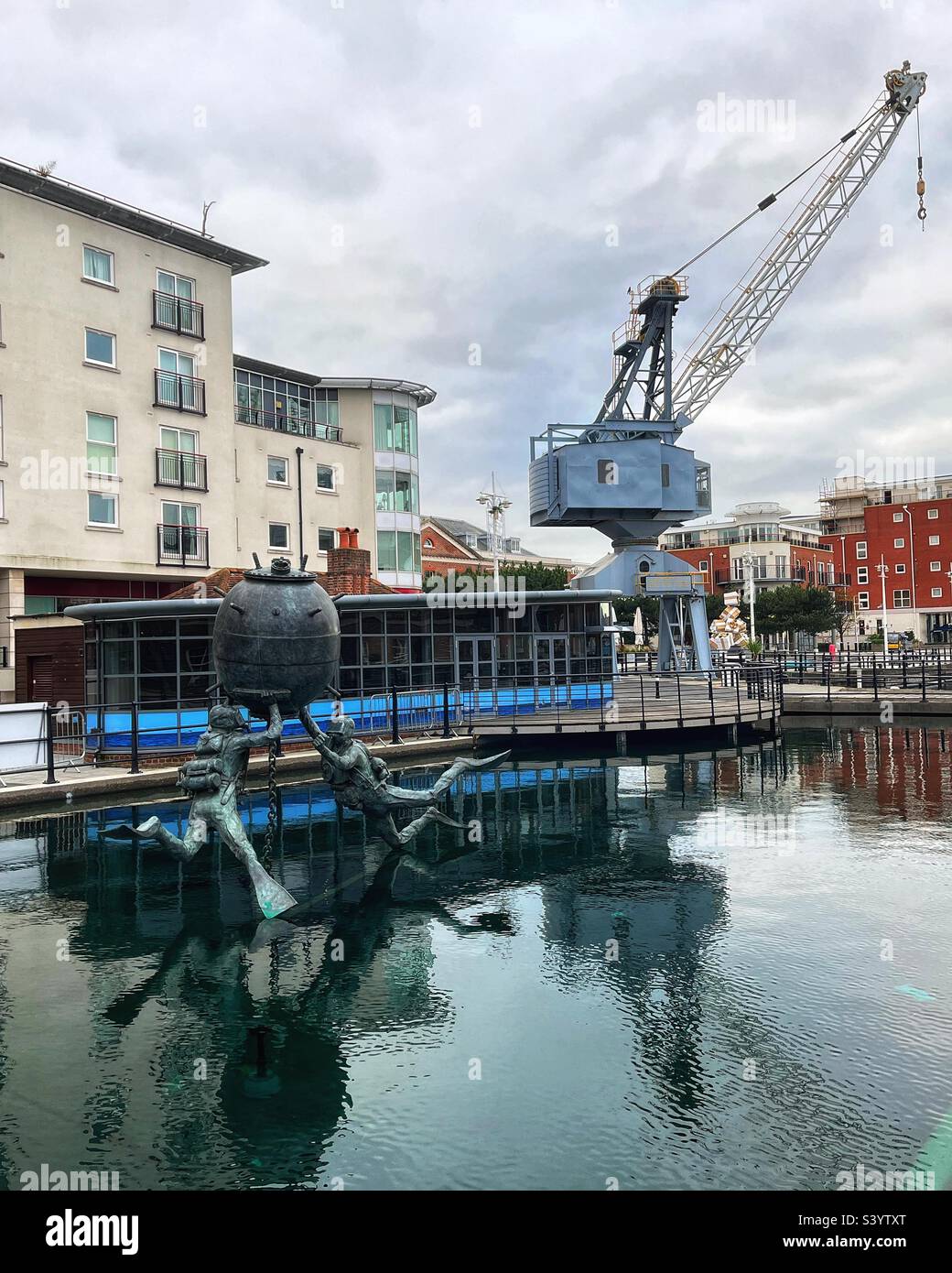 Vernon Mine Warfare & Diving Monument by sculptor Mark Richards FRSS comprises a moored mine with two attendant Clearance Divers seen Gunwharf Quays in Portsmouth the former site of HMS VERNON in situ Stock Photo