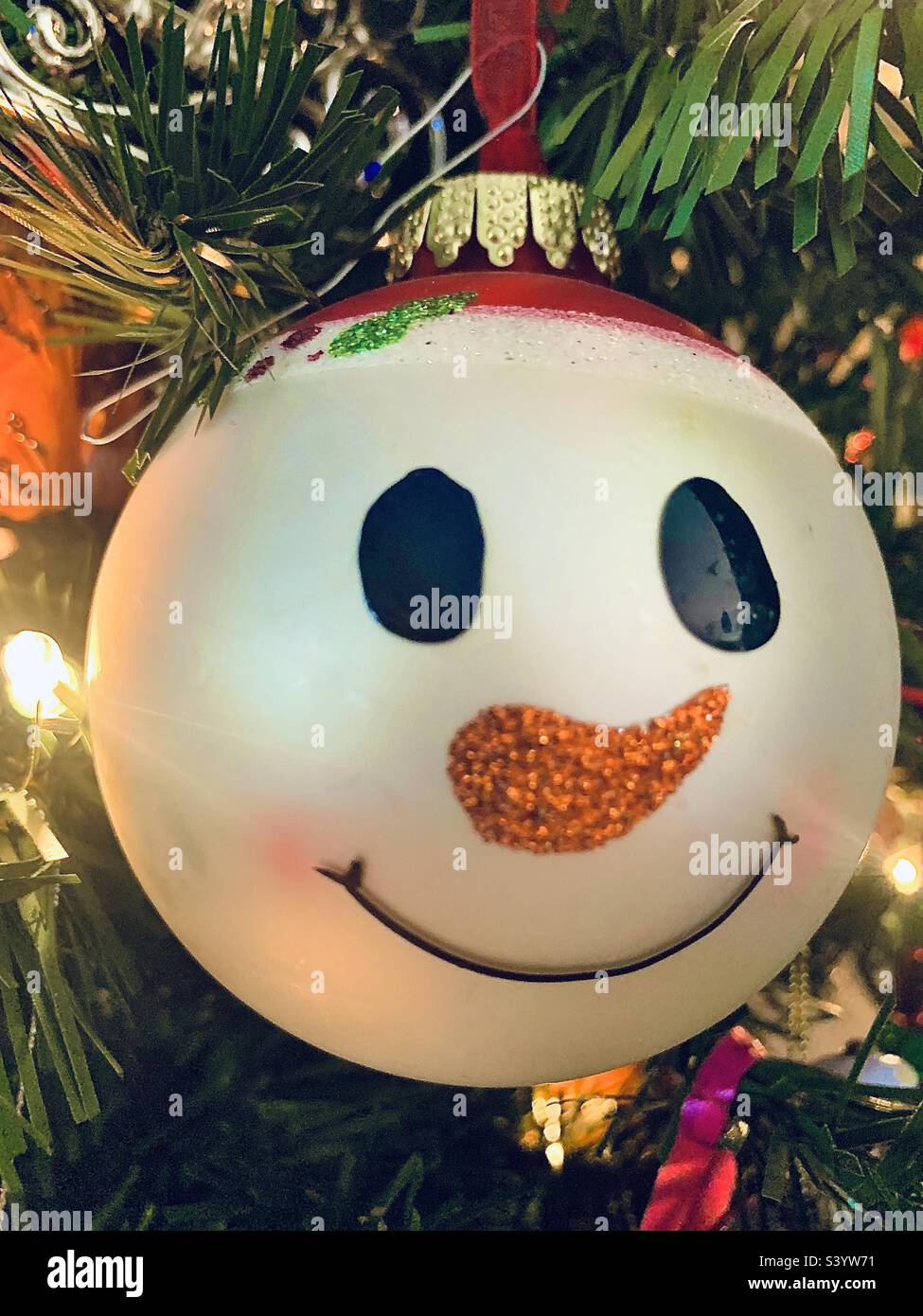 Snowman face Christmas ornament hanging on Christmas tree - Smartphone Captured Stock Image