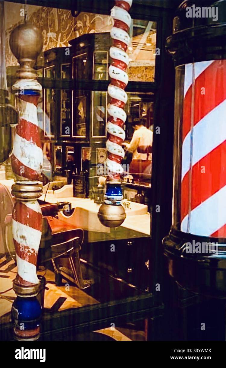Barber shop window display with different striped poles Stock Photo