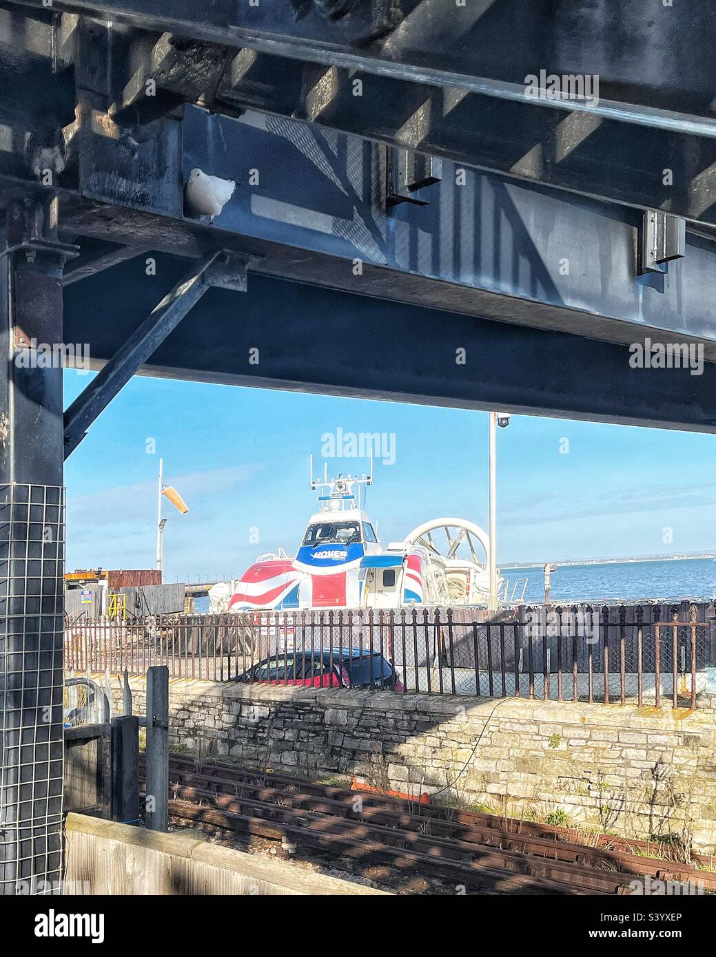 Doves under the railway footbridge at Ryde, Isle of Wight with hovercraft in the distance - Smartphone Captured Stock Image