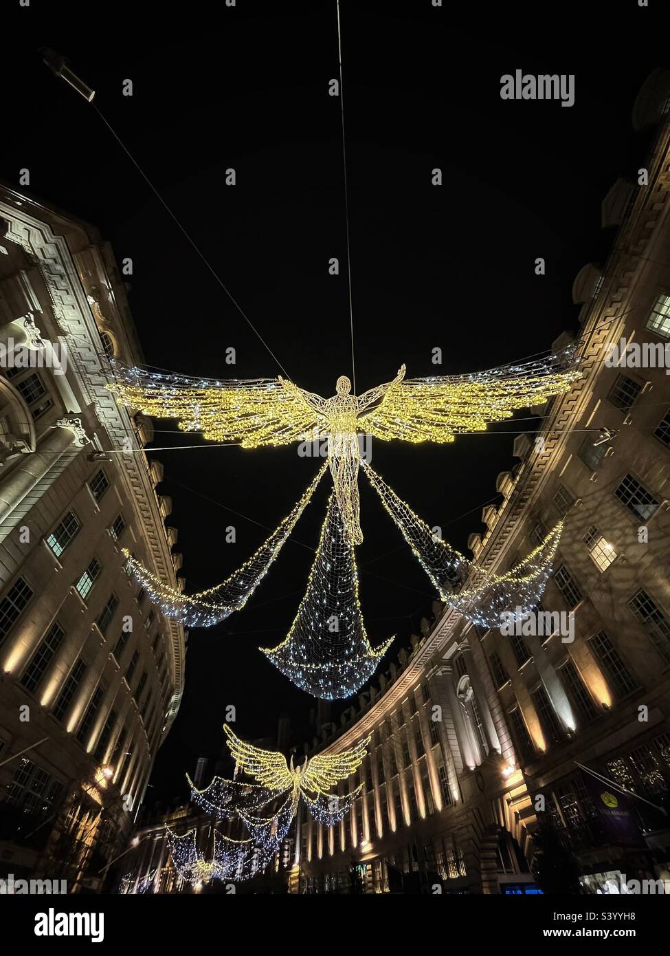 Series of angels across Regent Street in London for Christmas - sparkling fairy lights- sweeping curve of the road Stock Photo