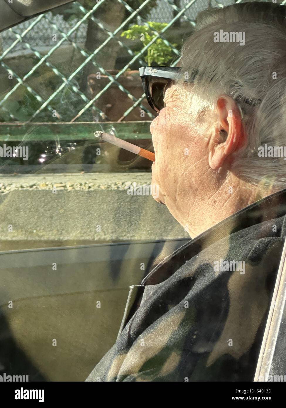 Old man smoking in his car - Smartphone Captured Stock Image