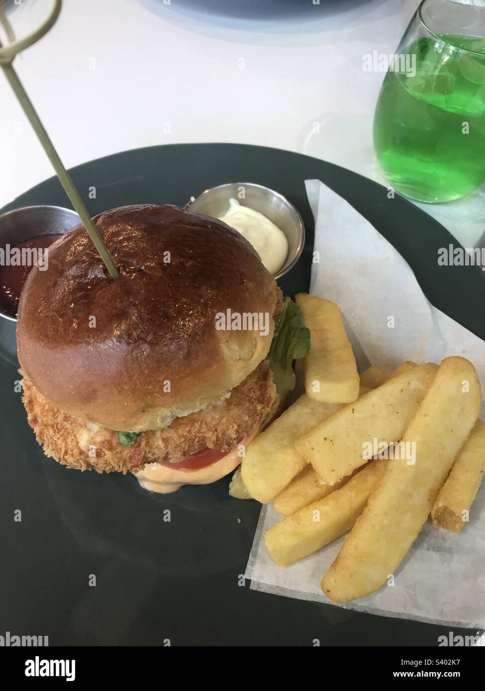 Crumbed chicken burger and chips Stock Photo Alamy