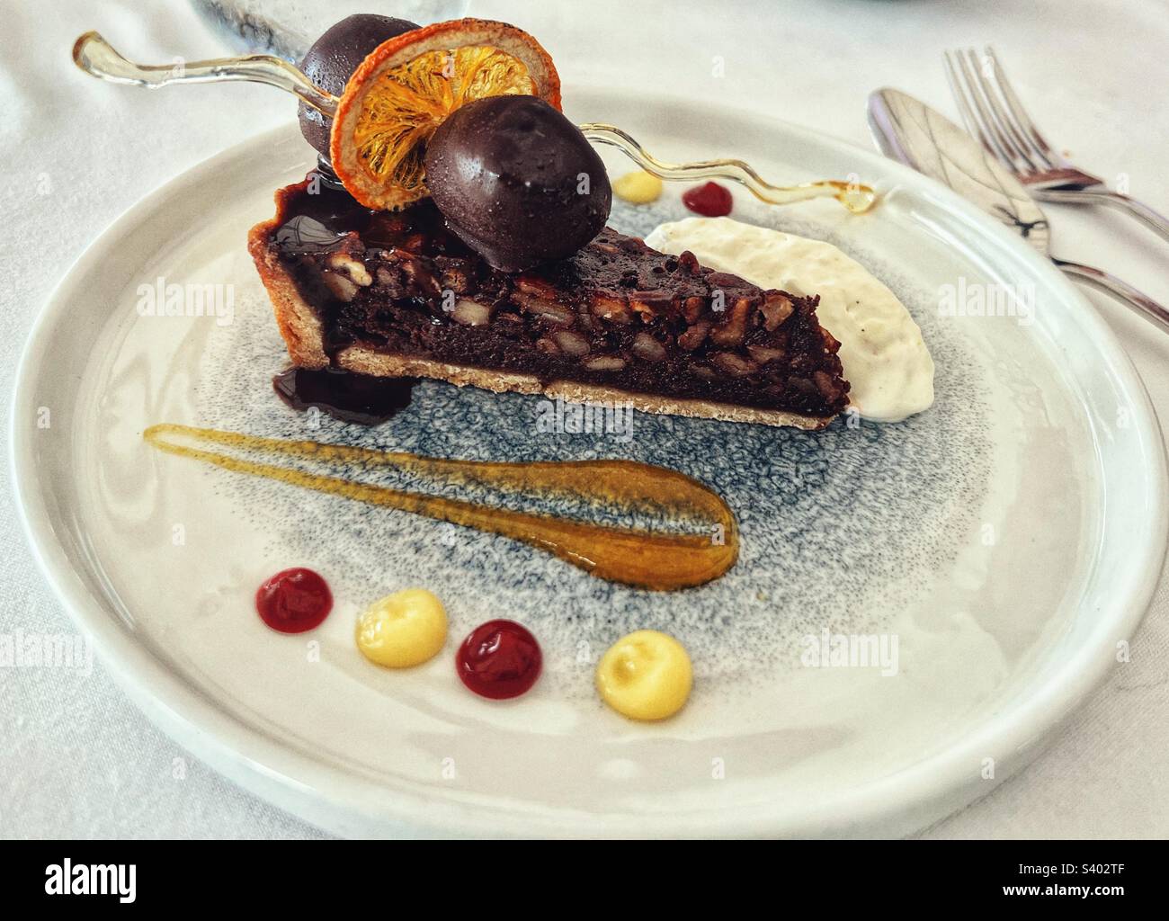Chocolate Pecan Pie on a plate with cream and coulis - Smartphone Captured Stock Image