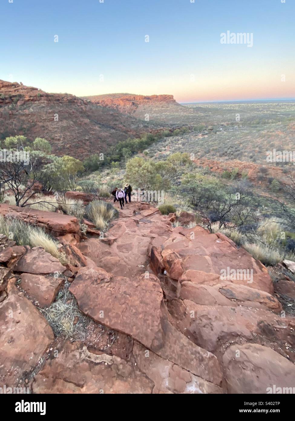 Hikers making early dawn start on the rim walk at Kings Canyon, NT, Australia. Hiking in remote wildness outback scenery in Northern Territory Stock Photo